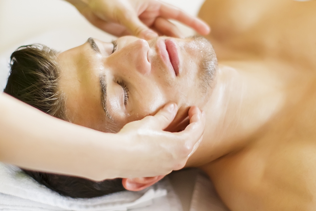 Man receiving a facial massage in a spa